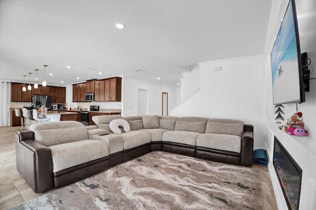 living room featuring light tile patterned floors, a glass covered fireplace, and recessed lighting