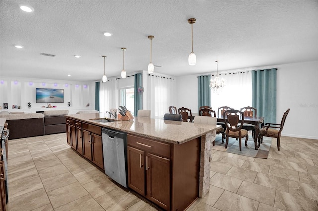 kitchen featuring a kitchen island with sink, a sink, visible vents, open floor plan, and stainless steel dishwasher