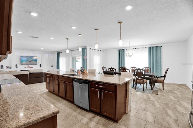 kitchen with dark brown cabinetry, a center island with sink, stainless steel dishwasher, pendant lighting, and a sink