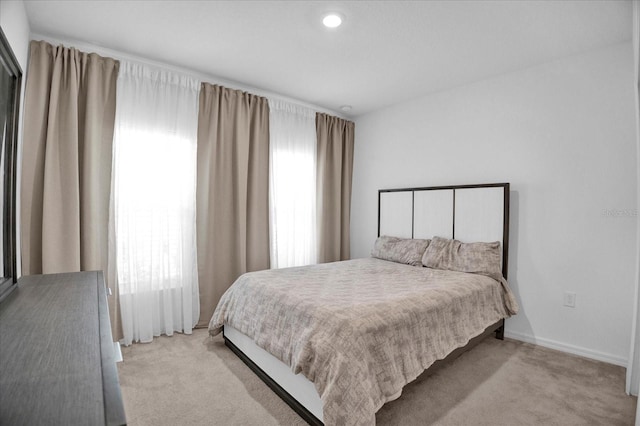 bedroom with light carpet and baseboards