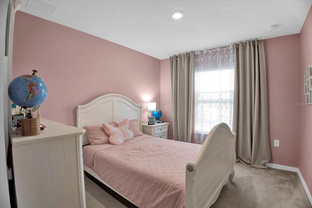 bedroom with baseboards and light colored carpet