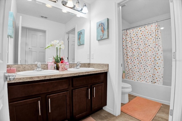 bathroom with visible vents, a sink, toilet, and double vanity