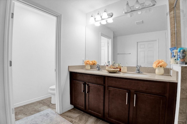 bathroom with visible vents, a sink, toilet, and double vanity