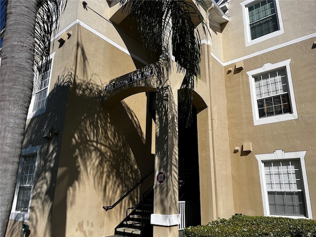 exterior space featuring arched walkways and stucco siding