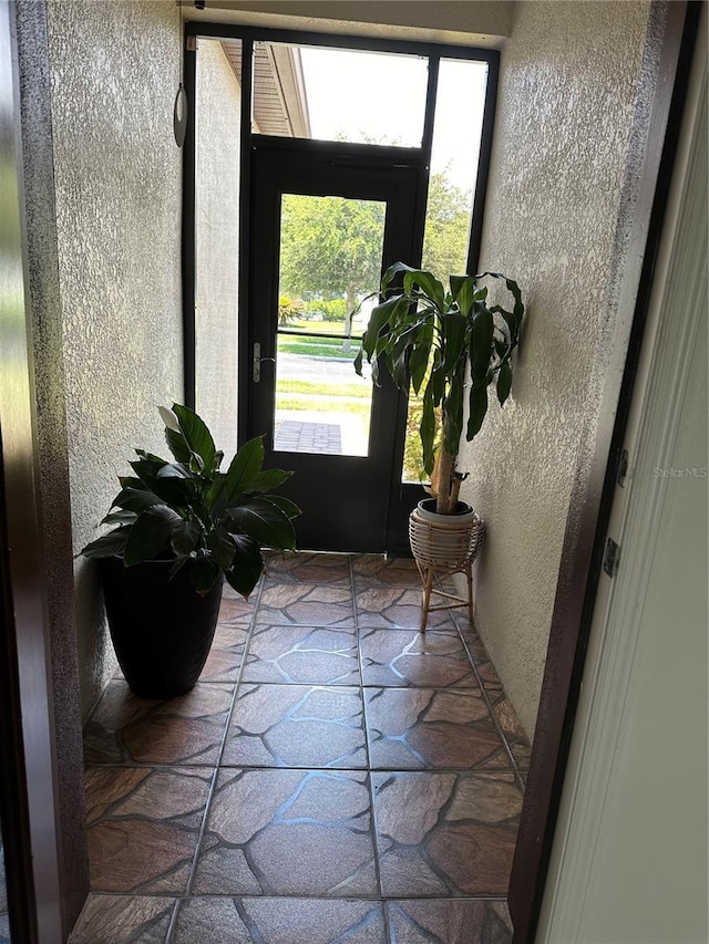 doorway to outside with a textured wall