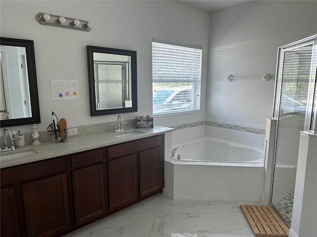 bathroom with a garden tub, double vanity, a sink, and marble finish floor