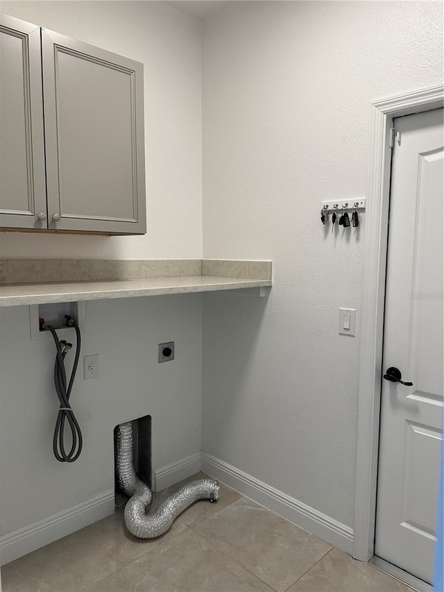 laundry area with light tile patterned floors, hookup for a washing machine, baseboards, cabinet space, and electric dryer hookup