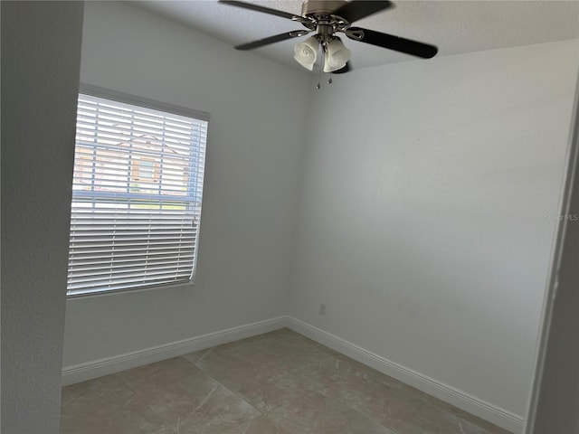 unfurnished room featuring baseboards and a ceiling fan