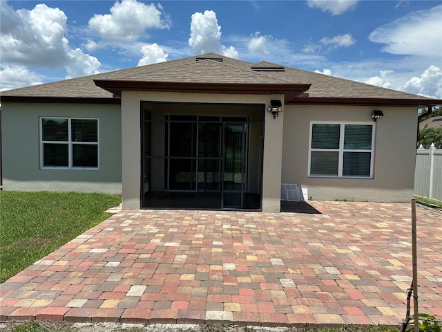 rear view of house with a patio, a shingled roof, and stucco siding