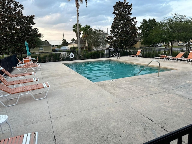 community pool with fence and a patio