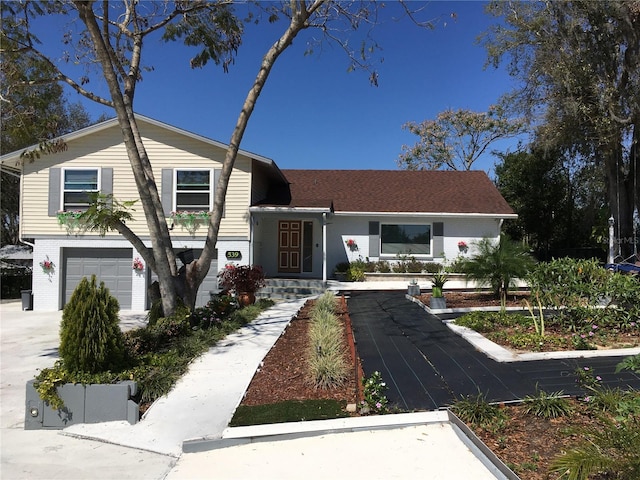 split level home with a garage and brick siding