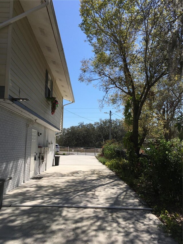 view of home's exterior featuring brick siding and fence