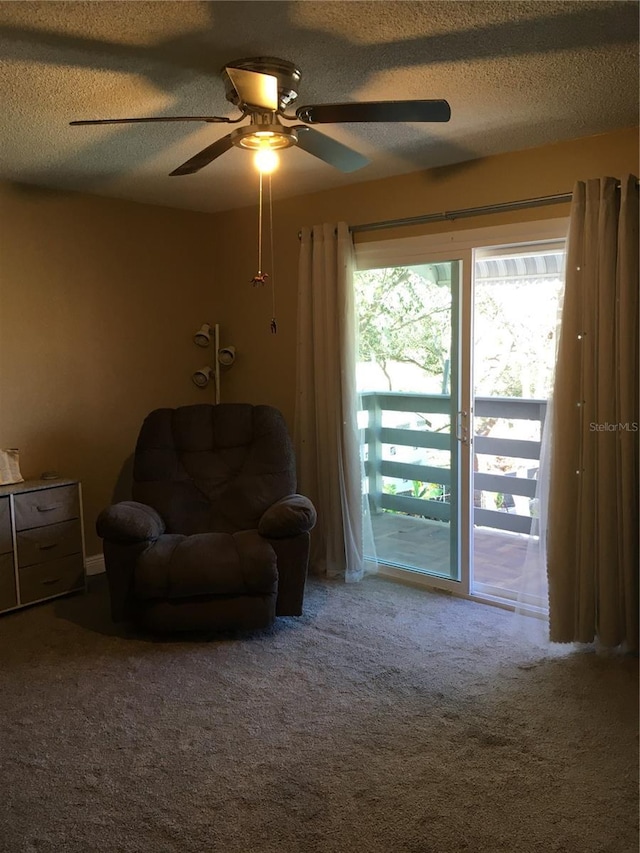 sitting room with a textured ceiling, ceiling fan, and carpet