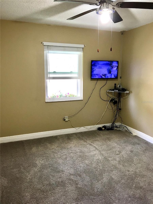 interior space featuring carpet floors, ceiling fan, baseboards, and a textured ceiling