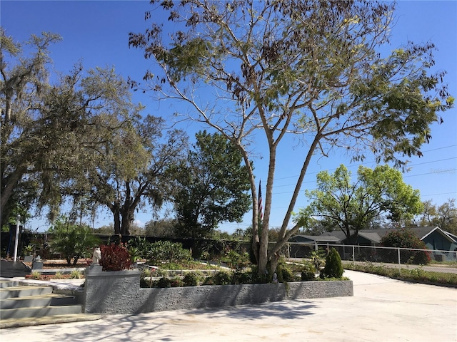 view of front of home with concrete driveway and fence