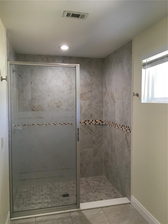 bathroom featuring a stall shower, baseboards, and visible vents