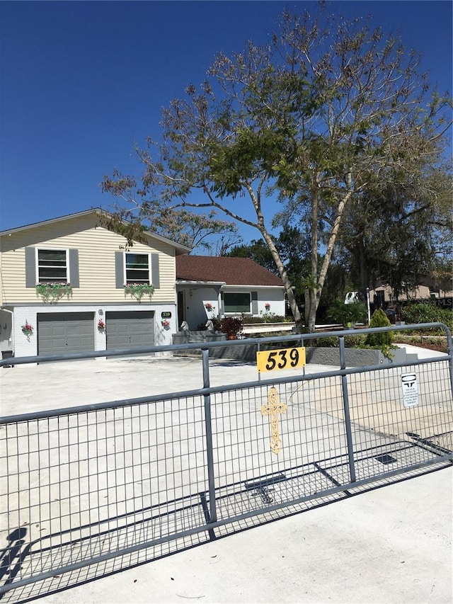 exterior space featuring a garage, driveway, and a fenced front yard