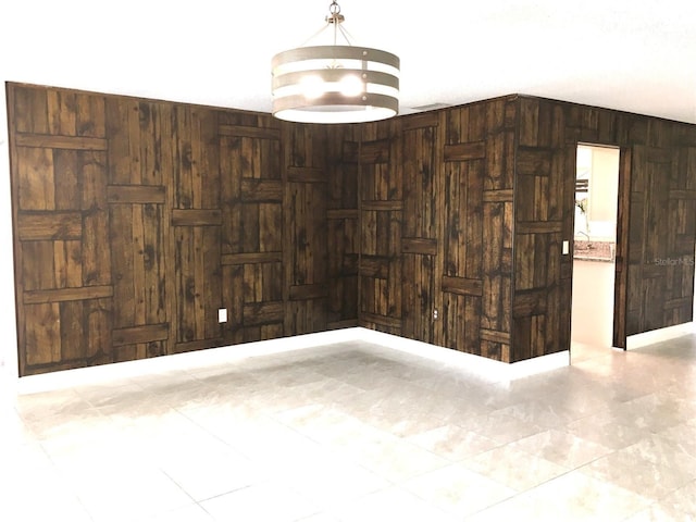 unfurnished room with wood walls