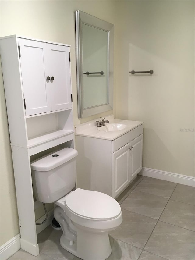 bathroom featuring baseboards, vanity, and toilet