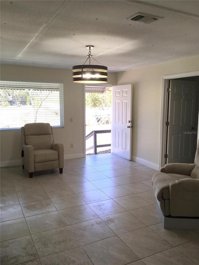 interior space with light tile patterned floors, visible vents, and baseboards