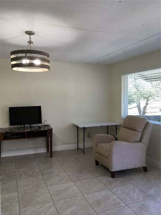 office space featuring a textured ceiling, light tile patterned floors, and baseboards