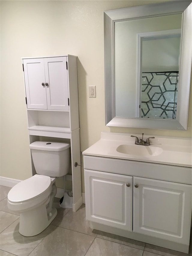 half bathroom with tile patterned flooring, baseboards, vanity, and toilet