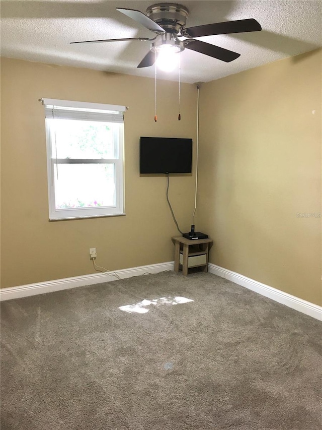 spare room featuring a ceiling fan, carpet flooring, a textured ceiling, and baseboards