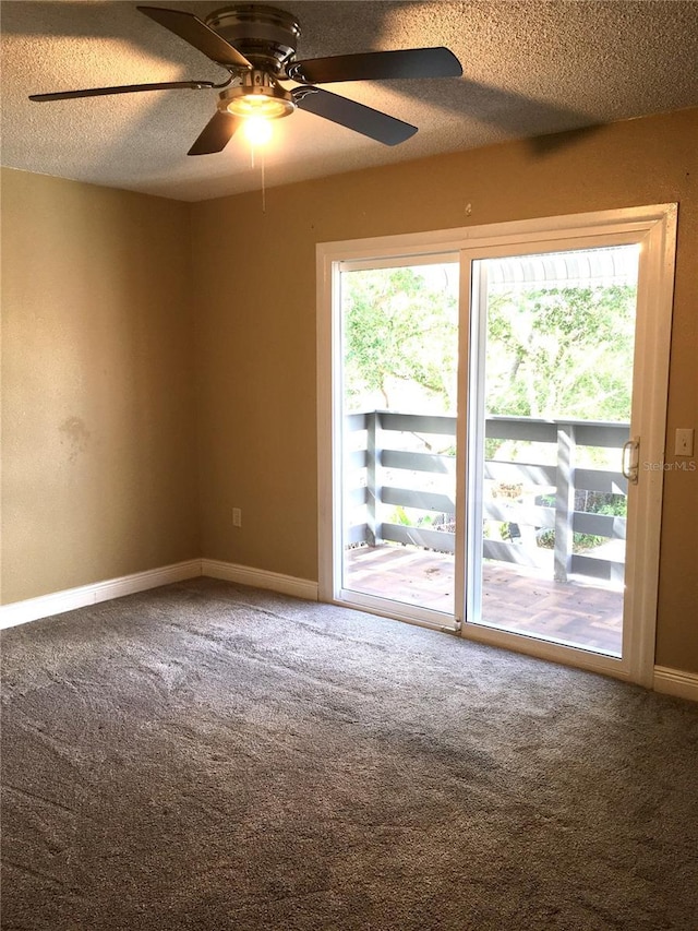 carpeted empty room with baseboards, a ceiling fan, and a textured ceiling