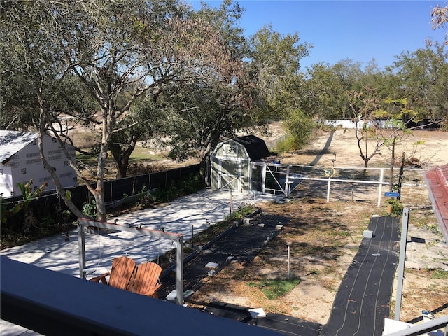 view of yard with a storage unit, fence, and an outdoor structure