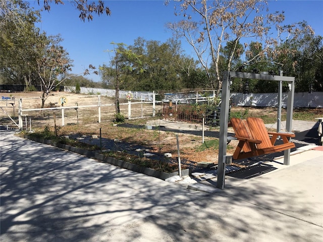 surrounding community with fence and a vegetable garden