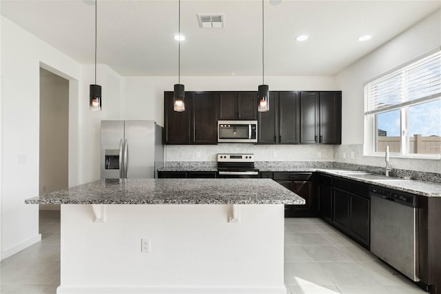 kitchen featuring appliances with stainless steel finishes, visible vents, a sink, and backsplash