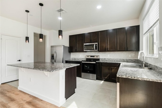 kitchen with tasteful backsplash, visible vents, stainless steel appliances, and a sink