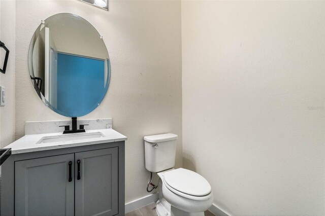 bathroom featuring wood finished floors, vanity, toilet, and baseboards