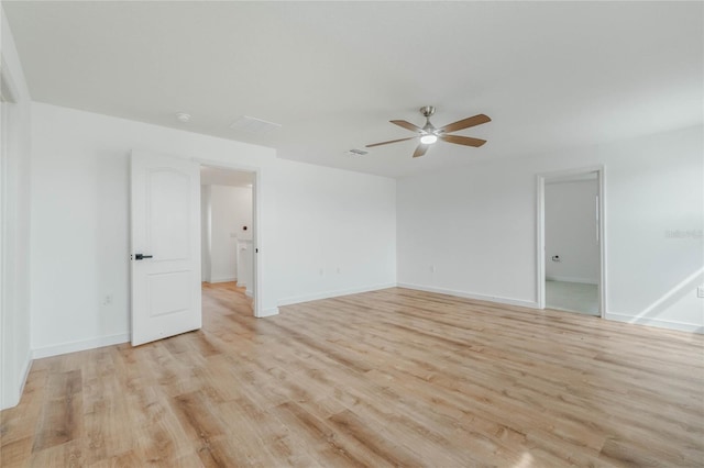 empty room with light wood-style flooring, visible vents, baseboards, and a ceiling fan