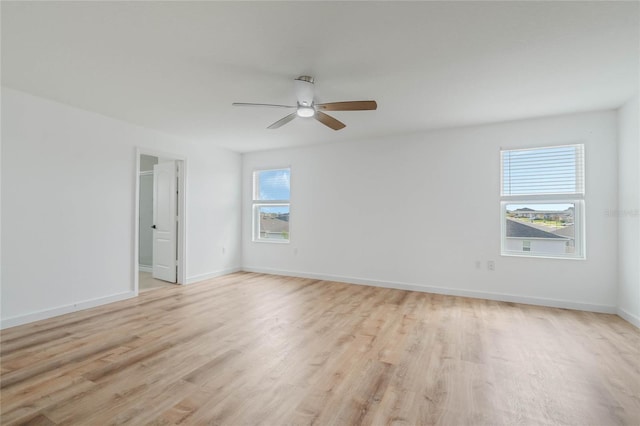 unfurnished room featuring light wood finished floors, a ceiling fan, and baseboards