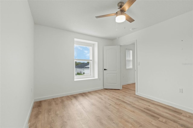 spare room with light wood-style floors, ceiling fan, and baseboards