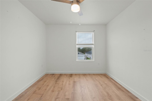 empty room with ceiling fan, light wood-style flooring, and baseboards