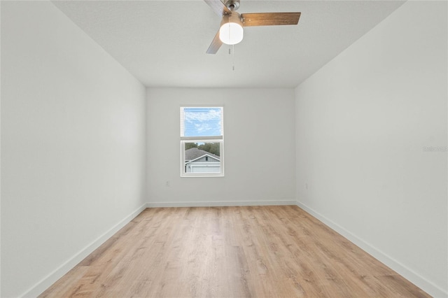 empty room with light wood finished floors, baseboards, and a ceiling fan