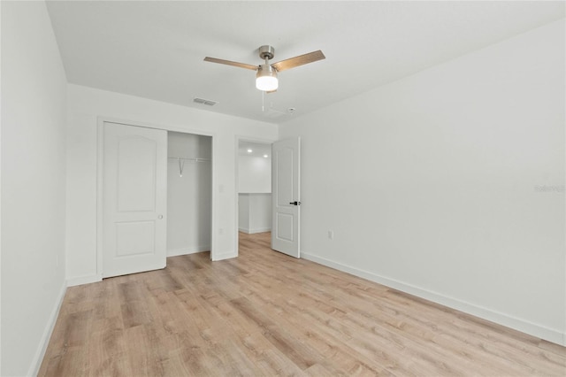 unfurnished bedroom with a closet, light wood-type flooring, visible vents, and baseboards