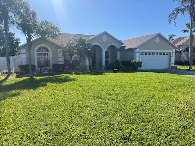 single story home with stucco siding, driveway, a front lawn, fence, and an attached garage