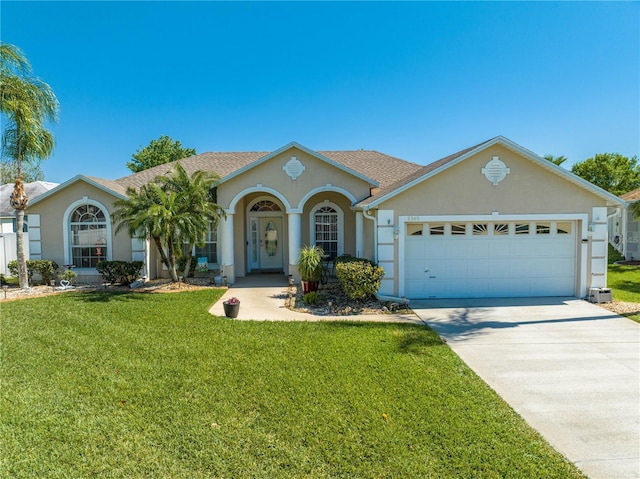 3303 Ann Arbor Ct, Saint Cloud, FL 34772 - view of front of house featuring a front lawn, driveway, stucco siding, and an attached garage