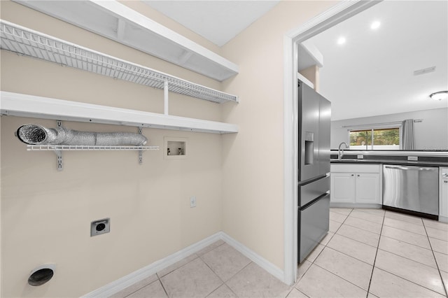3303 Ann Arbor Ct, Saint Cloud, FL 34772 - clothes washing area with a sink, hookup for an electric dryer, light tile patterned floors, washer hookup, and baseboards