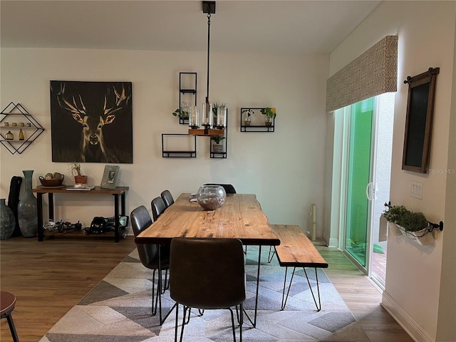 dining room featuring a healthy amount of sunlight, baseboards, and wood finished floors