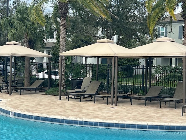 pool with a gazebo, a patio, and fence