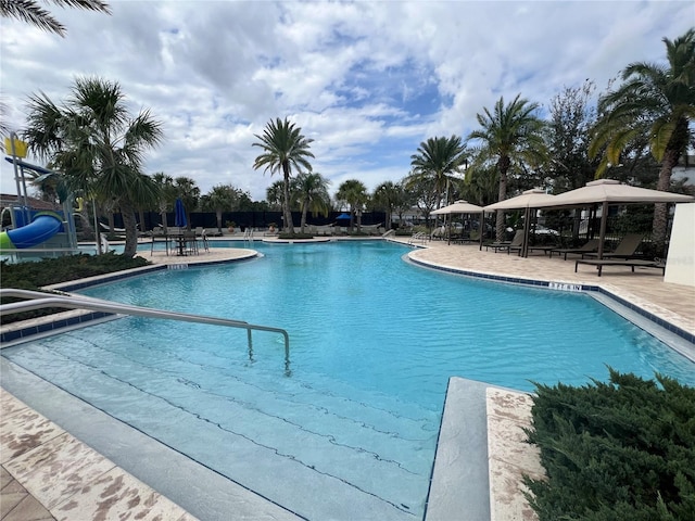 pool featuring a gazebo, a water slide, and a patio