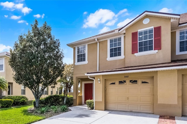 multi unit property with an attached garage and stucco siding