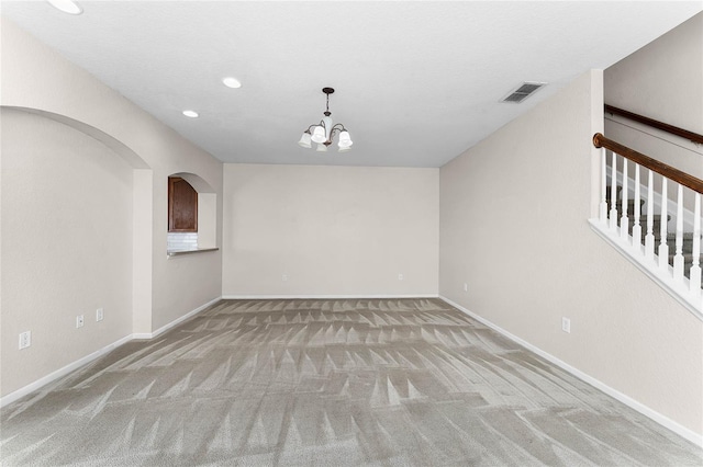 unfurnished room with baseboards, visible vents, a chandelier, and carpet flooring