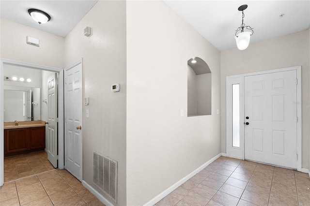 entrance foyer featuring visible vents, baseboards, and light tile patterned flooring