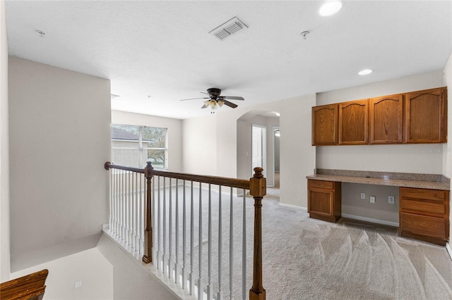 hallway featuring light carpet, baseboards, visible vents, arched walkways, and recessed lighting