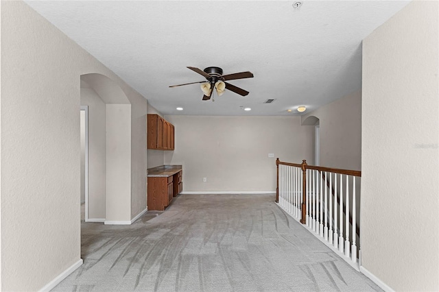 spare room featuring baseboards, visible vents, arched walkways, and a ceiling fan